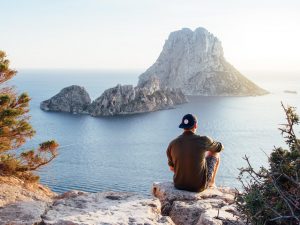 Man Sitting on Rock by Sea
